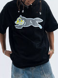Man in oversized black graphic t-shirt with cartoon wolf, streetwear style, blue jeans