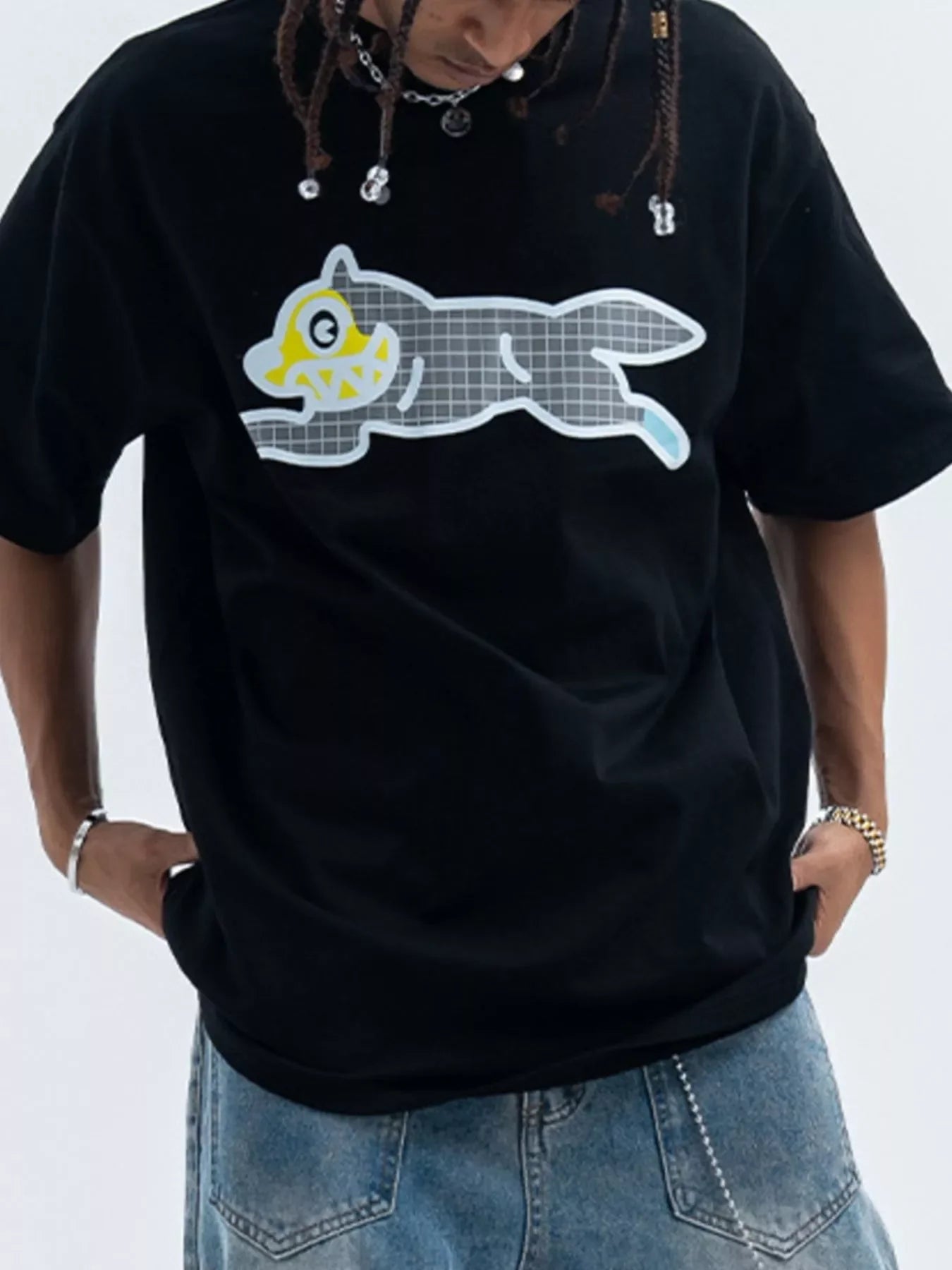 Man in oversized black graphic t-shirt with cartoon wolf, streetwear style, blue jeans