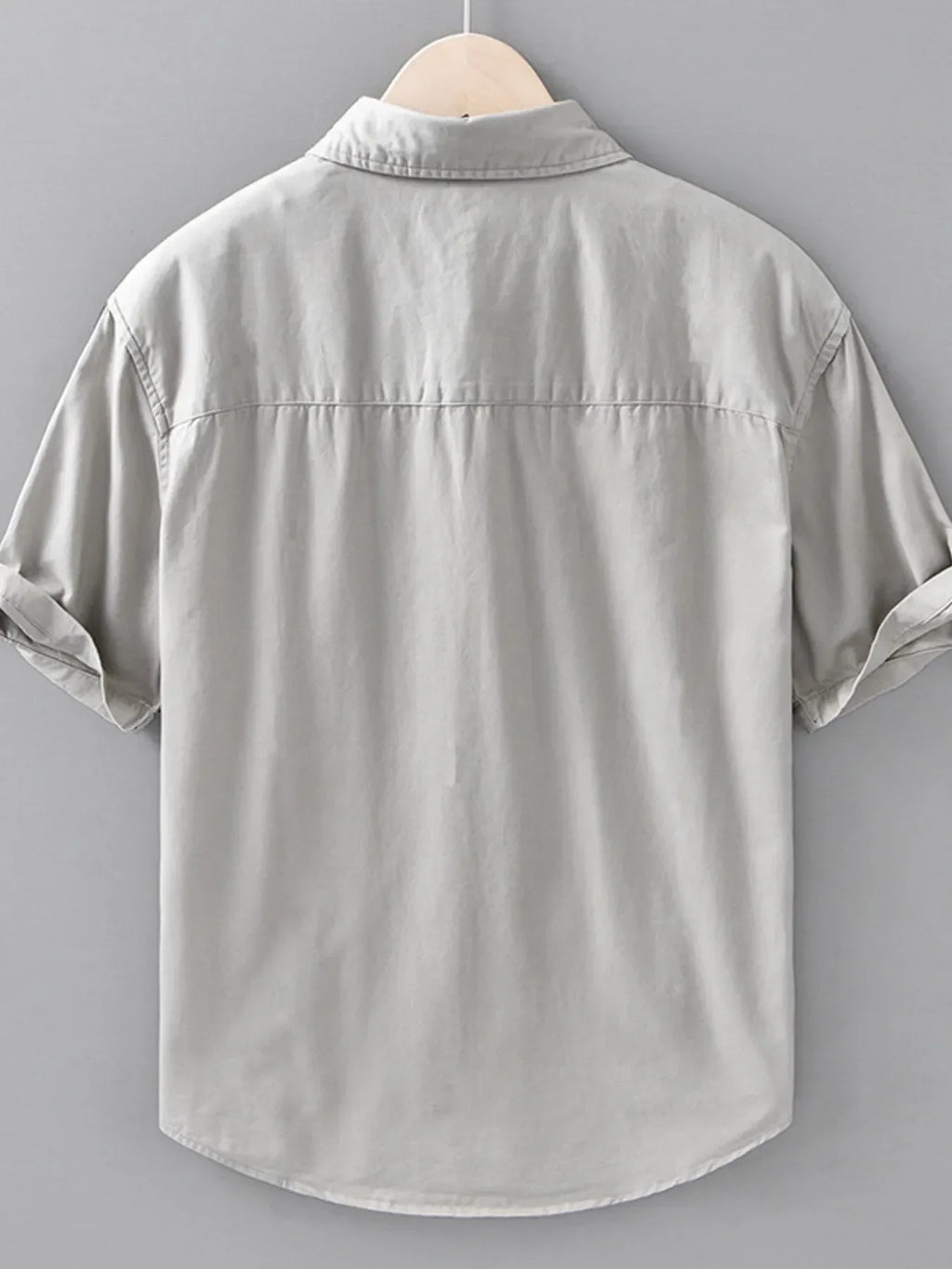 Back view of light grey short-sleeve streetwear shirt for men, plus size, hanging on hanger