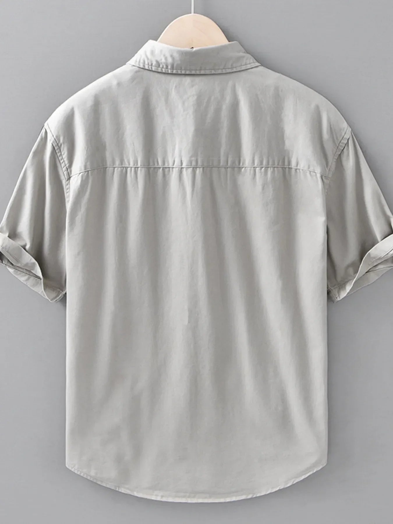 Back view of light grey short-sleeve streetwear shirt for men, plus size, hanging on hanger
