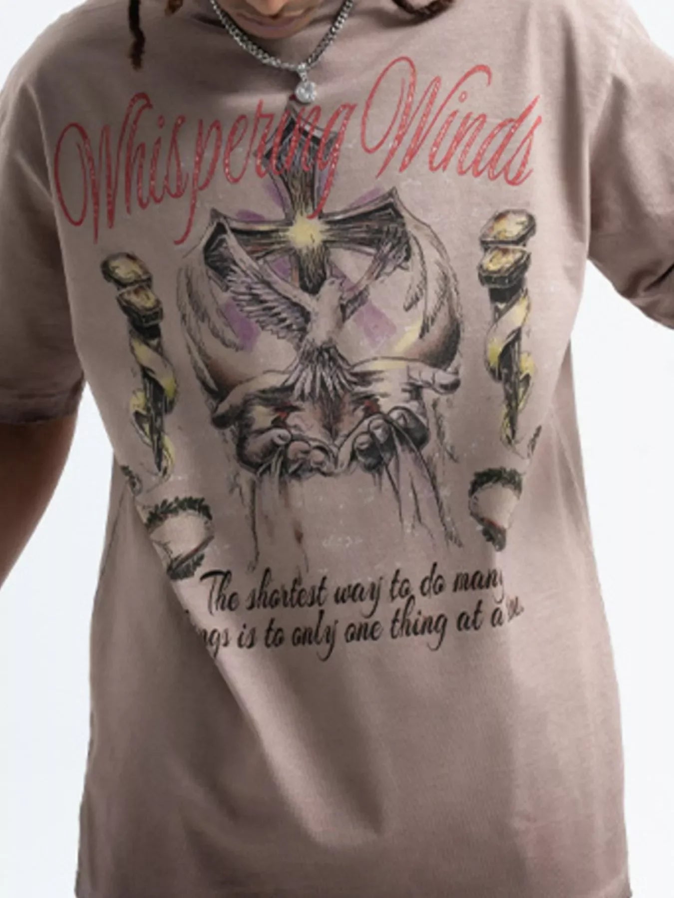Streetwear graphic t-shirt in oversized fit with dove, cross, and 'Whispering Winds' text.