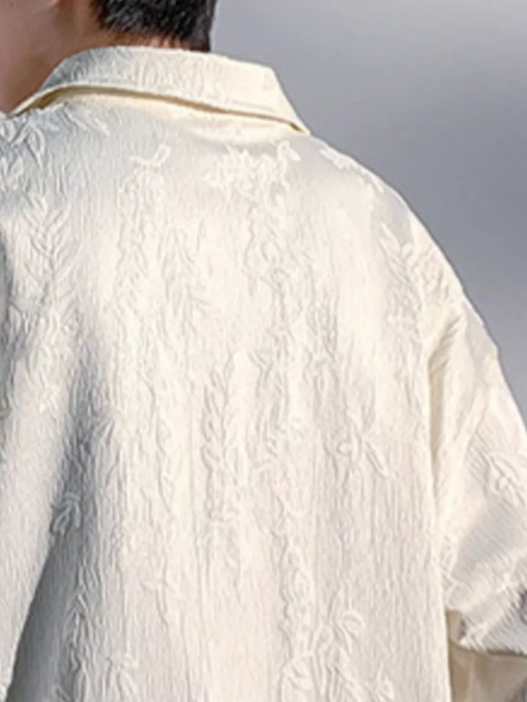 Close-up of a textured cream oversized shirt for men, streetwear style, plus size fit