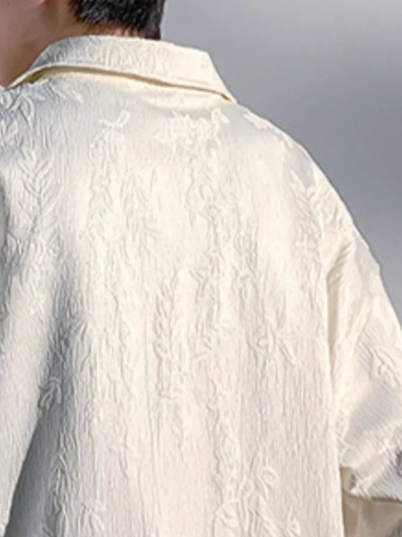 Close-up of a textured cream oversized shirt for men, streetwear style, plus size fit