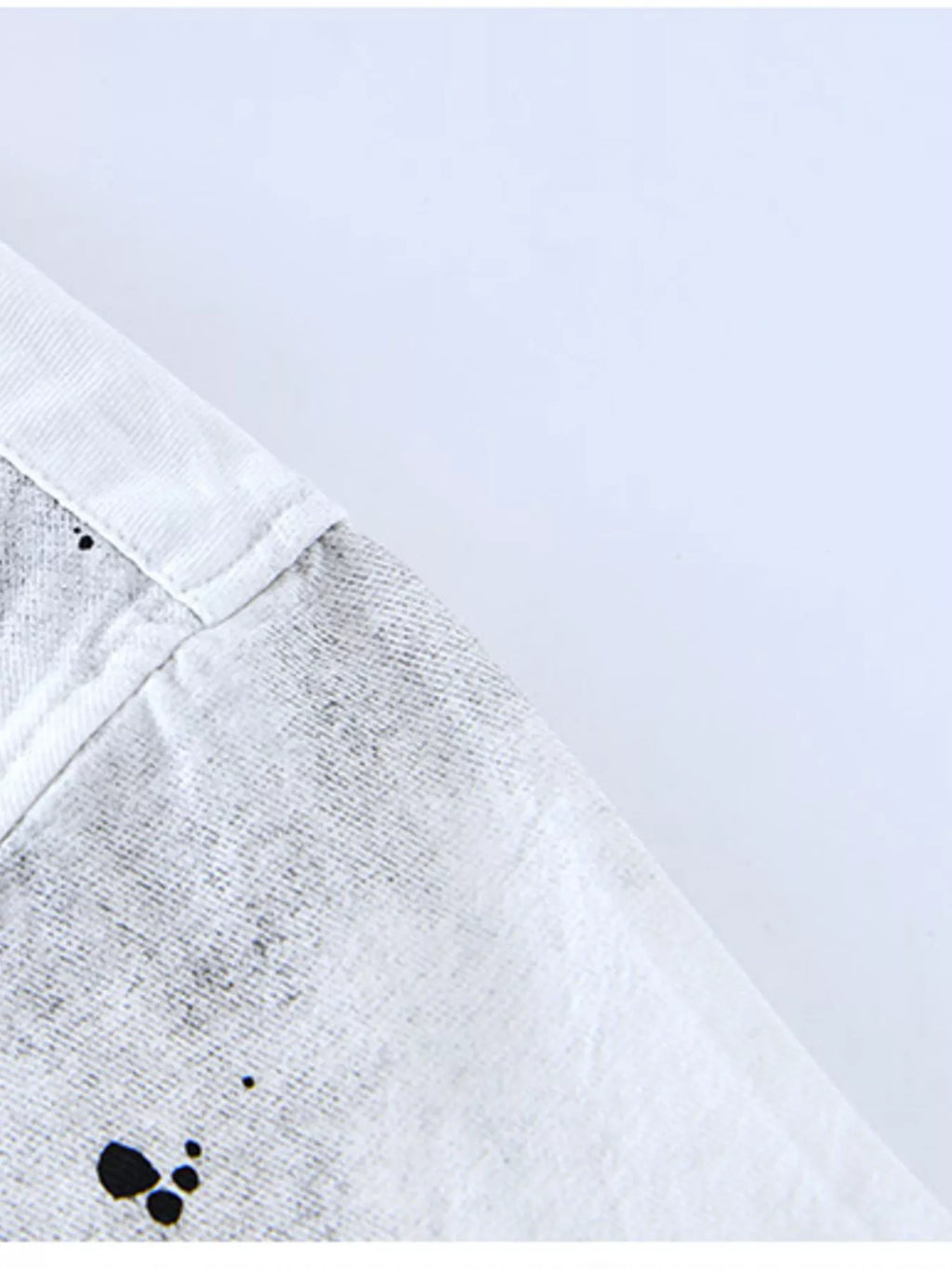 White streetwear t-shirt sleeve with black graphic splatter detail, urban fashion style