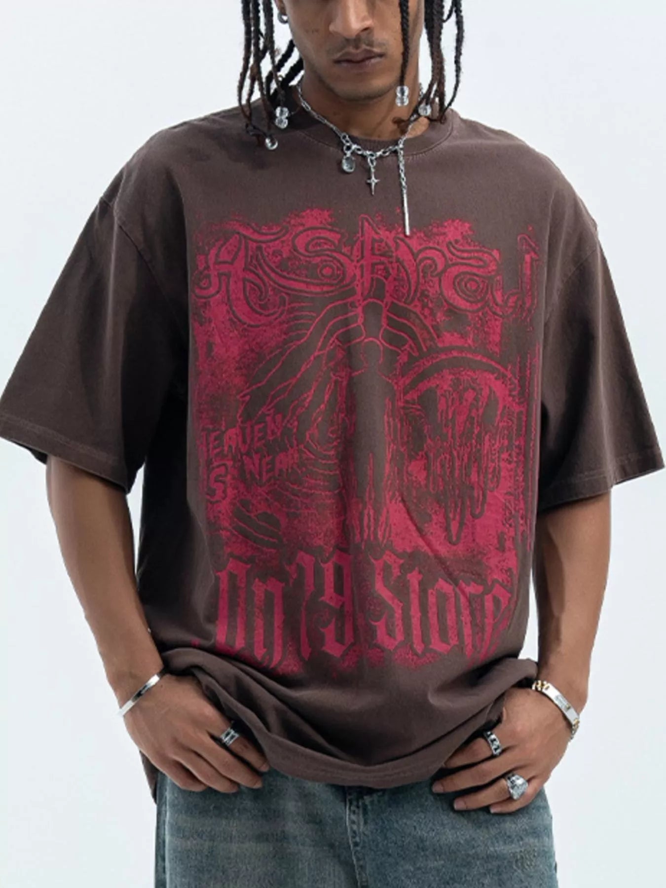 Man wearing oversized brown streetwear t-shirt with bold red graphic print and casual jeans