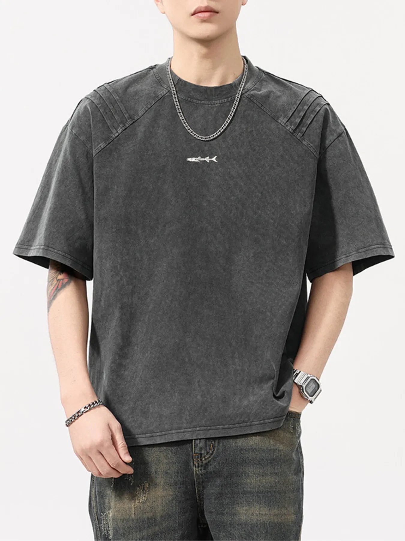 Man in oversized washed black streetwear t-shirt with shark graphic, urban jeans, chain necklace