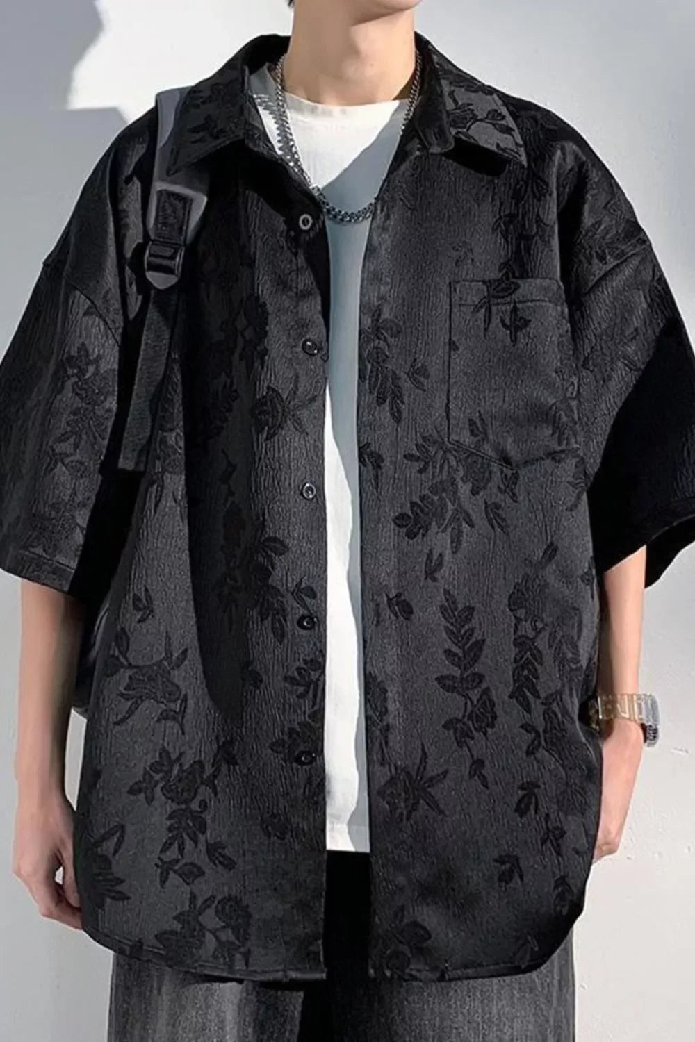 Oversized black floral short sleeve shirt for men, streetwear style, worn over white t-shirt