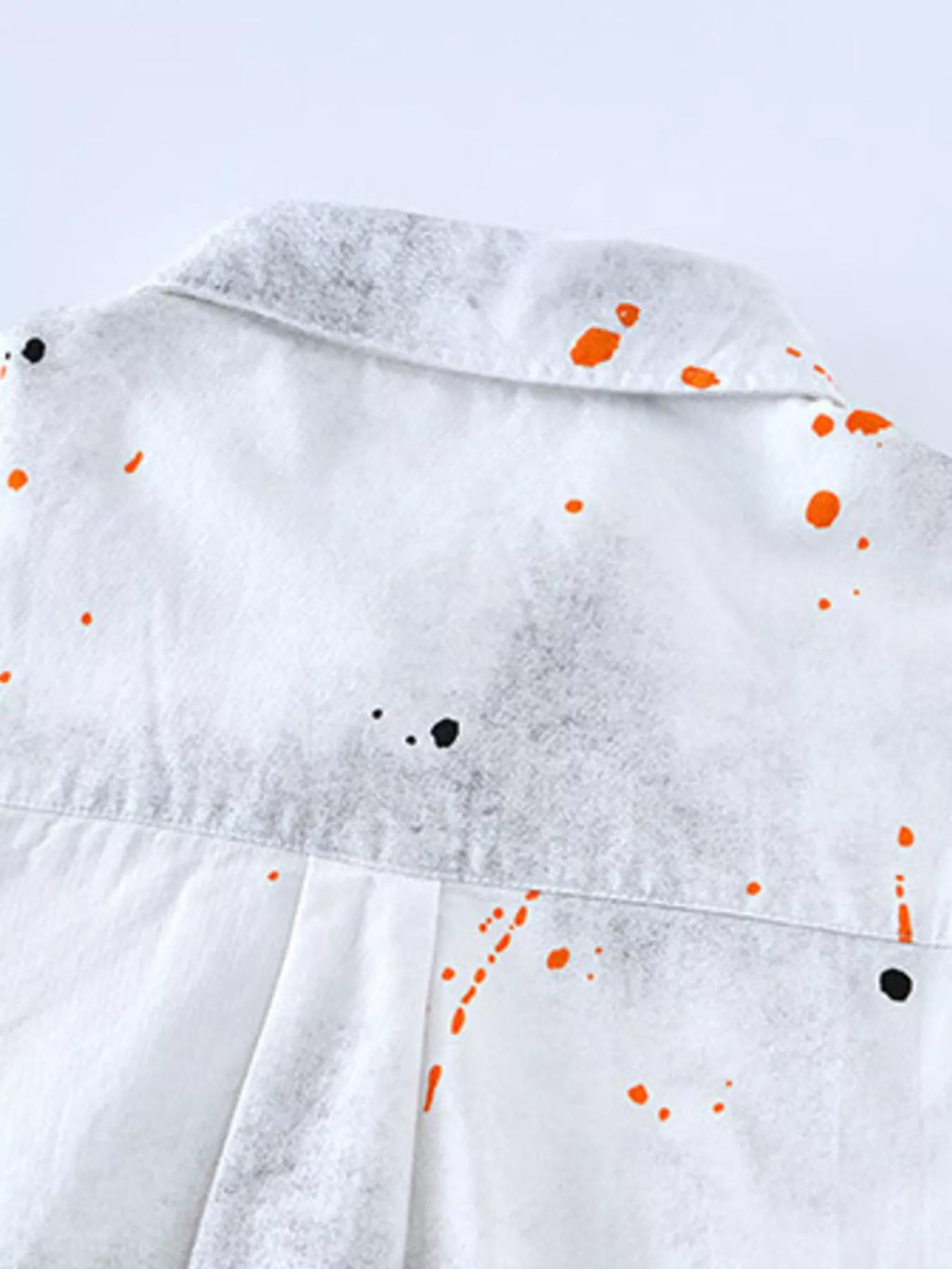 White streetwear shirt back with orange and black paint splatter, urban fashion style
