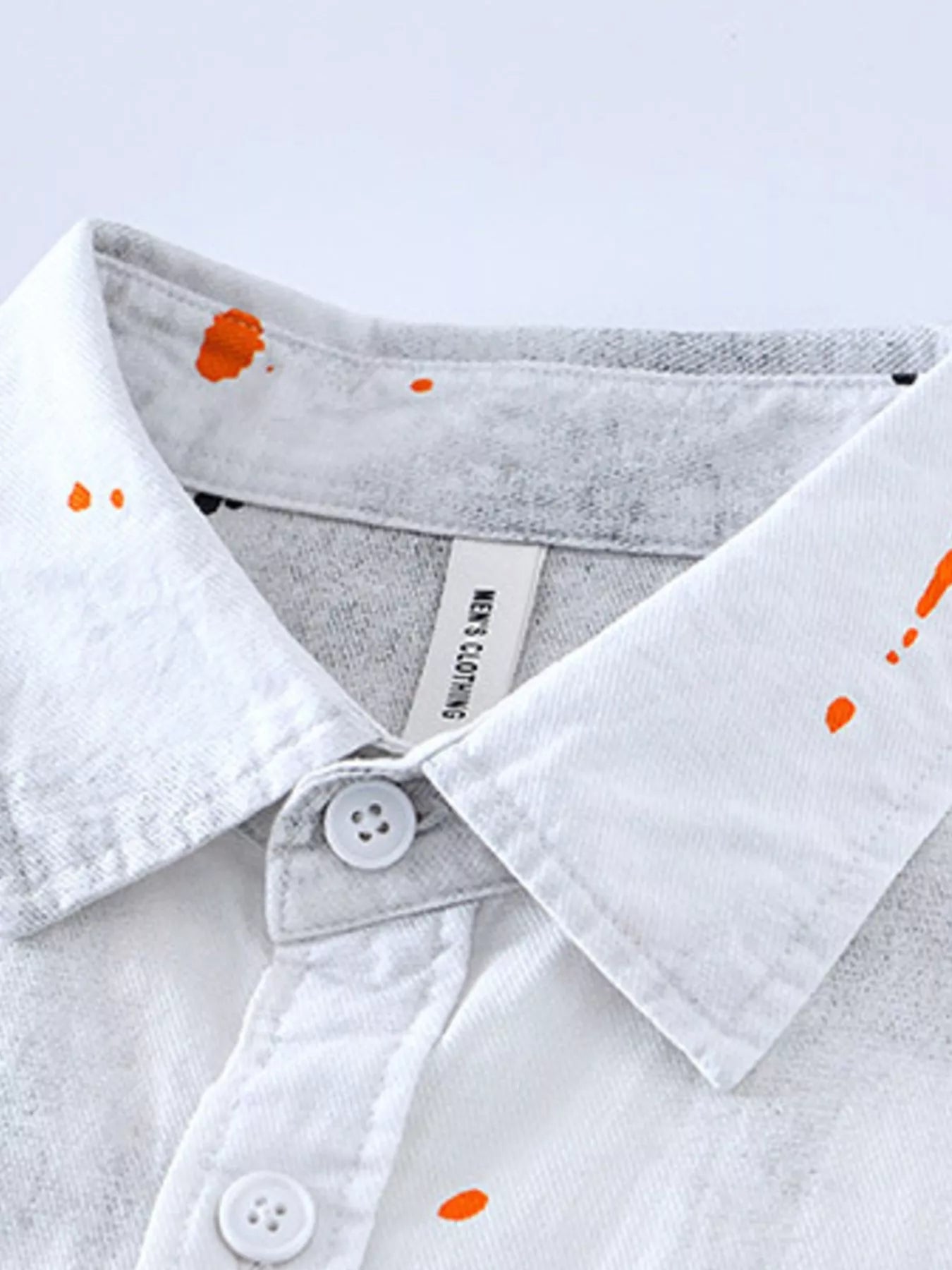 White streetwear shirt with orange paint splatters, button-down collar, urban fashion